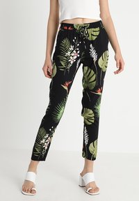 Zwarte joggerbroek met een tropisch bladeren- en bloemenpatroon, voorzien van een elastische tailleband, trekkoord en taps toelopende pasvorm.