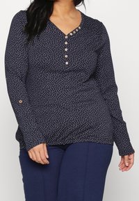 Námořnický top s dlouhým rukávem s bílými puntíky, véčkovým výstřihem s knoflíky a volným střihem s knoflíkovými rukávy. Měkká textura látky.