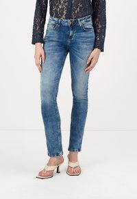 Jean skinny bleu clair en denim, doté de cinq poches, d'une fermeture à bouton et à zip, avec une légère décoloration pour un contraste de texture.