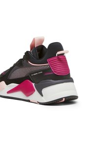 Chaussure de sport noire et rose avec une tige texturée, un talon rembourré et une semelle intermédiaire blanche contrastante. Présente un design rayé et une semelle extérieure en caoutchouc.