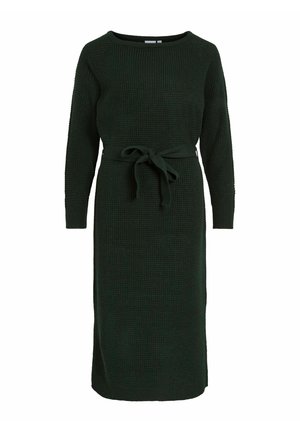Vestido de punto verde con mangas largas, escote redondo y cinturón de lazo en la cintura. Tela texturizada con un corte suelto y recto que llega hasta la mitad de la pantorrilla.