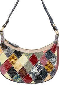 Een multikleuren patchwork-handtas met verschillende texturen. Het heeft een gebogen vorm, gouden hardware en een donkerblauwe schouderband.