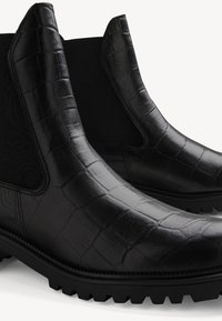 Mustat nahkaiset Chelsea-saappaat, joissa on krokotiilikuosi, elastiset sivupaneelit ja Texturoitu kumipohja pidon parantamiseksi.