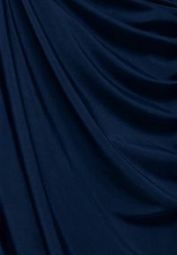 Tela azul marino con una textura suave, que exhibe caídas suaves y pliegues gentiles, creando una sensación de movimiento y profundidad.