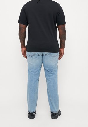 Czarna koszulka z krótkim rękawem, dopasowany krój. Jasnoniebieskie jeansy o prostych nogawkach, materiał dżinsowy, tylne kieszenie z detalem szwów. Czarne trampki.