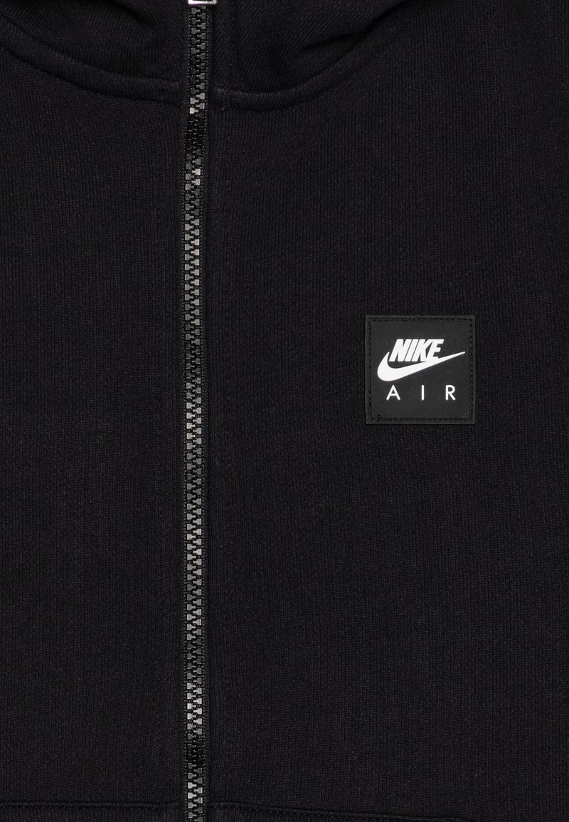 Schwarze Zip-Hoodie aus einem glatten Stoff. Ausgestattet mit einem auffälligen Nike Air Logo-Patch auf der linken Brustseite.