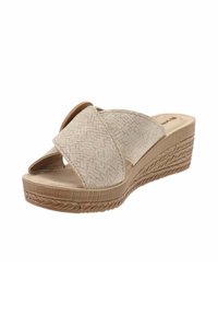 Sandales compensées beiges avec une texture tissée, un bout ouvert et des sangles croisées. La semelle présente un design tressé pour plus d'adhérence.