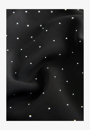 Tissu noir avec de petits pois blancs, régulièrement espacés, créant un motif à pois subtil sur une surface légèrement froissée.