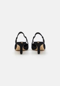 Black suede high-heeled sandals with a closed toe, slender ankle straps, and a small block heel. Smooth texture, minimal design details.