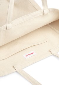 Borsa a spalla in cotone naturale, colore beige, design strutturato, due manici, tasca interna, texture leggermente maculata, etichetta del marchio all'interno.