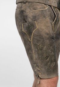Braune Lederhosen mit bestickten Blattmustern und gelben Nähten. Verfügt über eine Seitentasche und Schnürdetails am Saum.