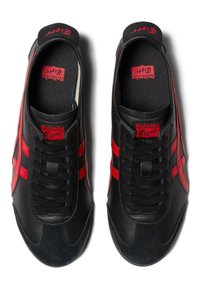 Black sneakers with red stripes, made from leather and suede, featuring a round toe, textured black laces, and branded insoles.