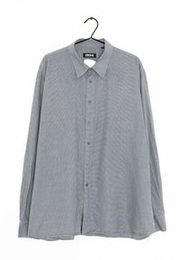 Camicetta a maniche lunghe DKNY, grigia con un sottile motivo a quadretti, con chiusura a bottoni sulla parte anteriore, colletto a punta e orlo dritto. Il tessuto appare liscio.