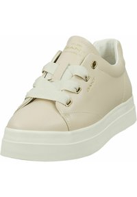 Baskets en cuir beige avec un design de lacets larges, œillets dorés et semelle en caoutchouc texturée. Style minimaliste avec col rembourré pour plus de confort.