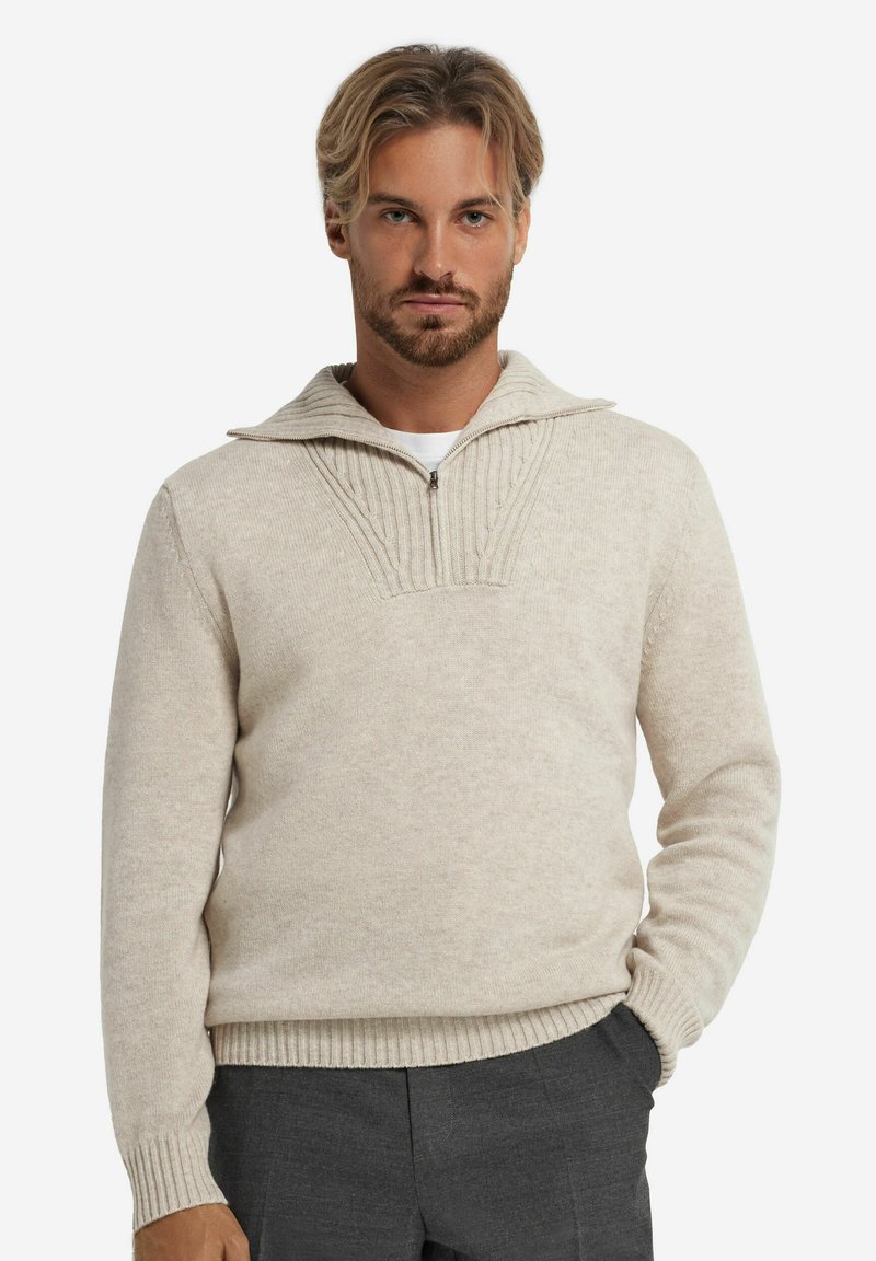 Beige Wolle Pullover mit halbem Reißverschlusskragen, strukturiertem Strickdetail an der Vorderseite, gerippten Bündchen und Saum. Figurbetonter Schnitt.
