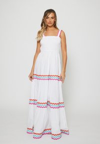 Abito maxi bianco con corpetto arricciato, caratterizzato da dettagli zigzag scallopati in rosa, turchese e arancione sull'orlo e sulle spalline.