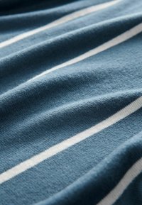 Blauw stof met subtiele textuur, met witte strepen die horizontaal lopen. Zacht, met een lichte glans en een gedrapeerd uiterlijk.