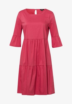 Lyserød knælængde kjole med trekvartlange klokkeærmer, rund halsudskæring og rynkede sømme ved talje og kant for en lagdelt effekt.