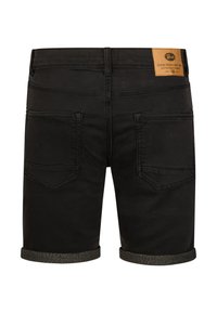 Zwarte denim shorts met opgerolde zoom en twee achterzakken, voorzien van een beige leren merklabel op de tailleband.