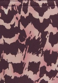 Tissu à motifs présentant un design abstrait bordeaux et rose. Texture lisse avec un léger éclat et des formes irrégulières dans tout le tissu.