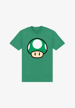 T-shirt verde in cotone con una grande grafica di un fungo verde con macchie bianche e un cappello beige, contornato di nero.