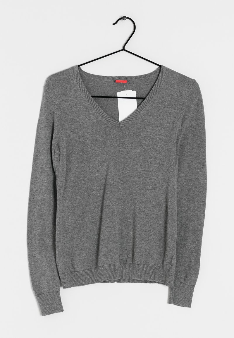 Pull gris à manches longues avec col en V, suspendu à un cintre noir sur un fond blanc, avec une étiquette de prix blanche attachée au niveau de l'encolure.