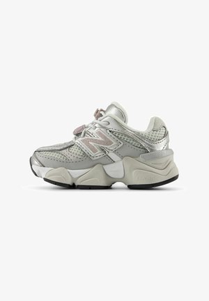 Baskets de sport New Balance grises et blanches avec dessus en mesh et cuir, semelle épaisse et rembourrée, et logo sur le côté, vues de l'extérieur.
