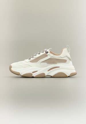 Weiß-beige klobiger Sneaker mit strukturierter Sohle, Mesh- und Lederobermaterial, grauen Schnürsenkeln und Zuglasche an der Ferse.