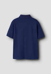 Polo de color azul marino con cuello, mangas cortas y una tela texturizada. La parte trasera es lisa sin logotipos ni acentos visibles.