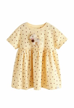 Žlté šaty s krátkym rukávom pre batoľa s hnedými bodkami a malým plyšovým jednorožcom pripevneným na hrudi.