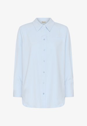 Világoskék, hosszú ujjú, gombos ing hegyes gallérral és egyetlen mellzsebbel, fehér háttér előtt bemutatva.