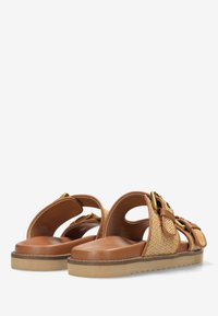 Hnědé skluzné sandály s tkanou texturou, zlatými kovovými akcenty, otevřenou zadní částí a silnou podrážkou s vlnkovým okrajem.