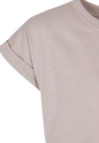 Lys beige kortermet t-skjorte laget av mykt bomullsmateriale, med rund hals og rullede ermkanter med en ren finish.