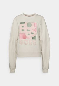 Felpa beige chiaro con una grande grafica "BOSS" multicolore in rosa e verde. Scollo rotondo e polsini a costine.