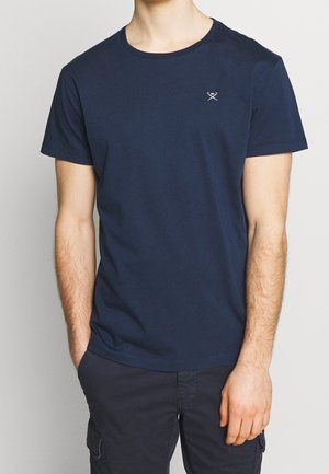 Granatowa bawełniana koszulka z okrągłym dekoltem i krótkimi rękawami. Posiada mały haftowany wzór na lewej piersi.