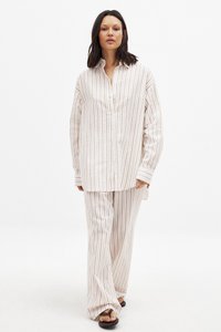 Zestaw składający się z koszuli zapinanej na guziki i spodni w jasnym beżu z cienkimi pionowymi paskami. Miękka tkanina o luźnym kroju, długie rękawy i szerokie nogawki spodni.