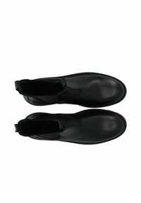 Bottines noires en cuir avec une texture lisse, des panneaux latéraux élastiques et des languettes de tirage, présentant un design minimaliste et un bout arrondi.