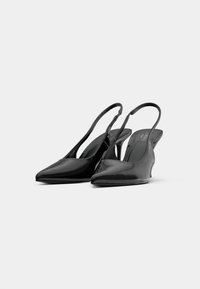 Čierne lakované kožené slingback podpätky s špicatou špičkou, zakriveným podpätkom a otvoreným zadným dizajnom; hladká textúra a minimalistická estetika.