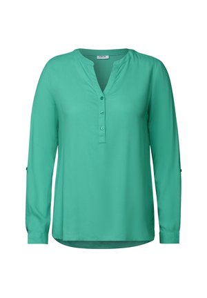 Blusa azzurra con bottoni, scollo a V, maniche lunghe, morbida al tatto e orlo leggermente curvato. Presenta una cucitura con bottoni.