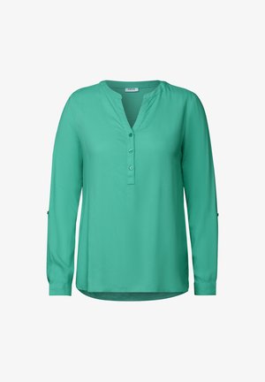 Blusa abotonada turquesa con escote en V, mangas largas, textura suave y un dobladillo ligeramente curvado. Presenta una tapeta con botones.