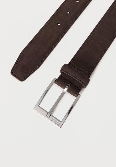 Ceinture en daim brun foncé avec boucle rectangulaire argentée gravée "BOSS" sur fond blanc.