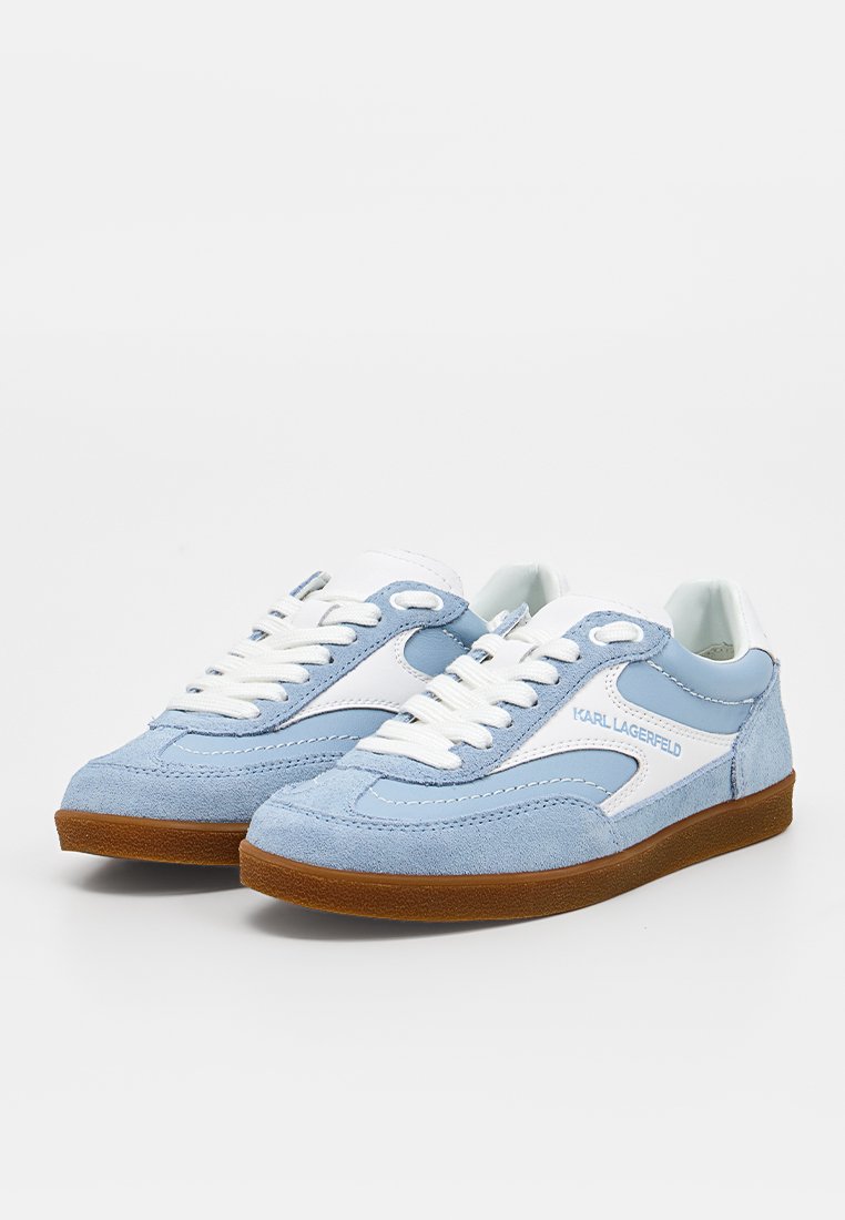 Zapatillas de ante azul claro y blanco con cordones blancos y suelas de goma marrones, con la marca "KARL LAGERFELD" en el lateral.