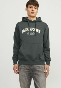 Szara bluza z kapturem i sznurkiem, z białym logo "JACK&JONES" na wysokości klatki piersiowej. Gładki materiał oraz ściągacze przy mankietach i u dołu; luźny krój.