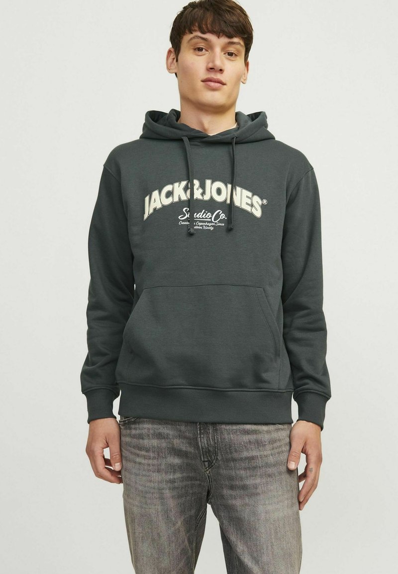 Szara bluza z kapturem i sznurkiem, z białym logo "JACK&JONES" na wysokości klatki piersiowej. Gładki materiał oraz ściągacze przy mankietach i u dołu; luźny krój.