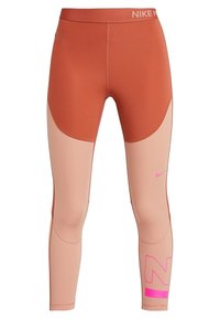 Leggings Nike con un design a blocchi di colore in tonalità ruggine e pesca chiaro. Presentano un dettaglio del logo rosa e un materiale aderente e stretchy.