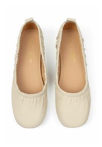 Beige leather ballet flats with gathered elastic edges, rounded toe, and a smooth finish. Inside shows a tan insole with gold text.