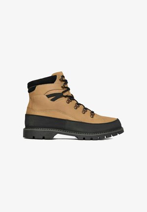 Tan and black hiking boot with black laces, metal eyelets, padded collar, and thick textured sole, shown in side profile on white background.
