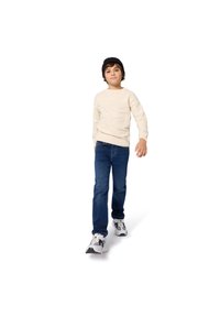 Sweater de malha creme com padrão texturizado, jeans de denim azul e sapatilhas pretas. Criança a andar contra um fundo branco.