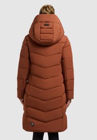 Brauner Puffer-Mantel mit Chevron-Muster, einer großen Kapuze und Fronttaschen. Der Stoff wirkt glatt und gepolstert für bessere Isolierung.