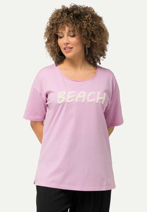 Růžové tričko s krátkým rukávem s nápisem "BEACH" v bílém texturovaném písmu, kulatým výstřihem a bočními rozparky pro snadný pohyb.